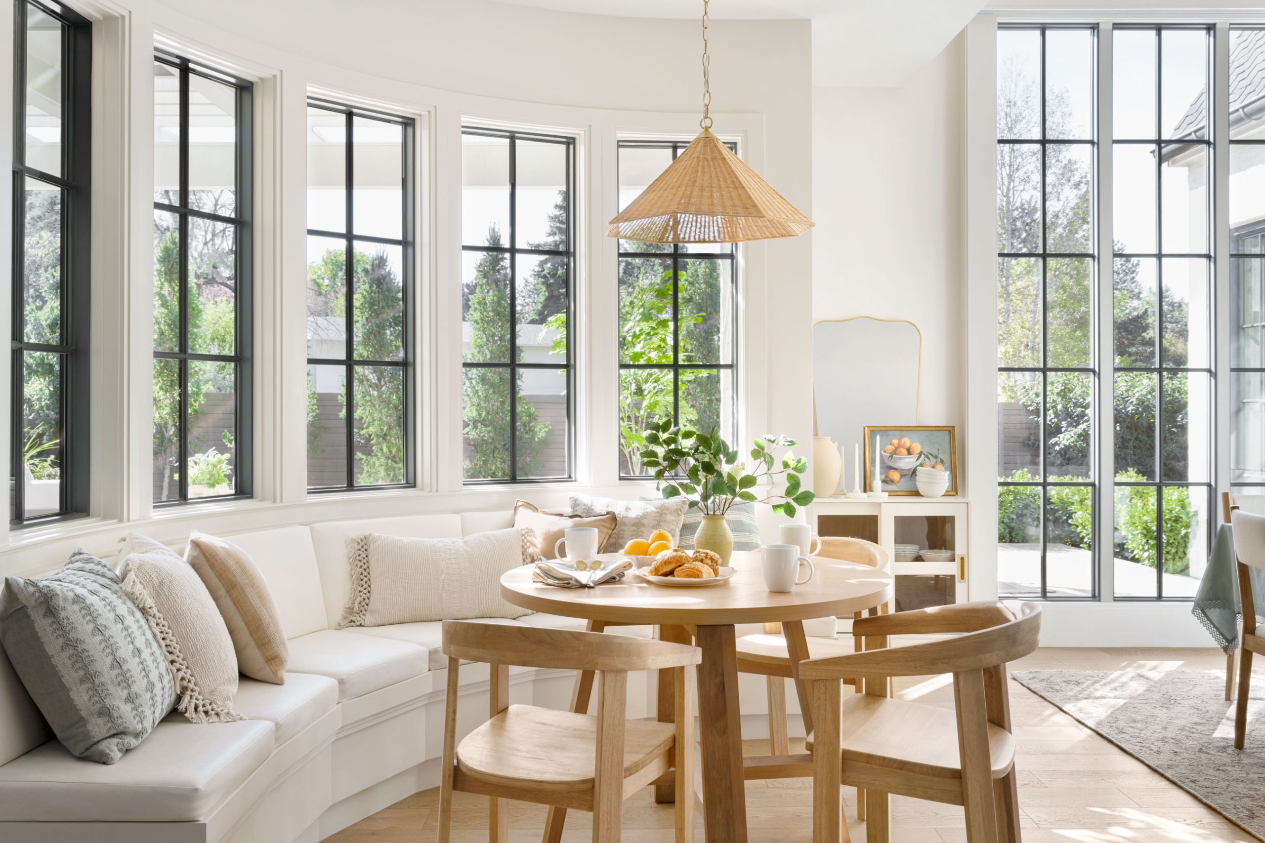 Kitchen nook with bench and round table with rattan pendant